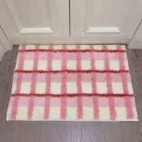 Tapis rose de décoration ou de bain à carreaux avec touche de blanc