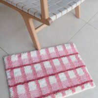 Tapis rose de décoration ou de bain à carreaux avec touche de blanc