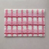 Tapis rose de décoration ou de bain à carreaux avec touche de blanc